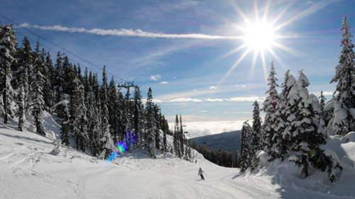 skier on groomed run on sunny day